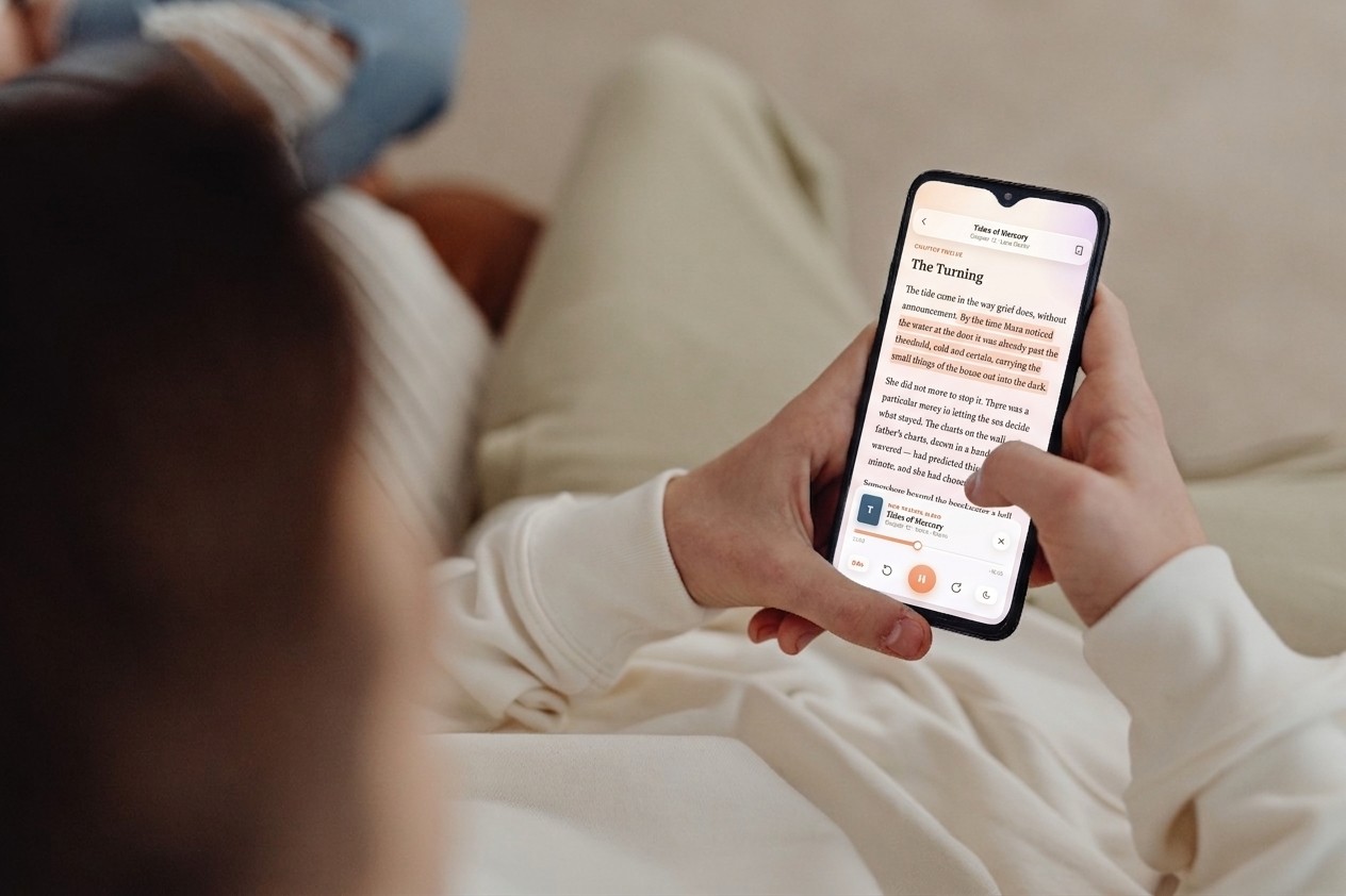 Next Chapter open on a phone held in the lap, showing the reader with a live highlight and the read-aloud player